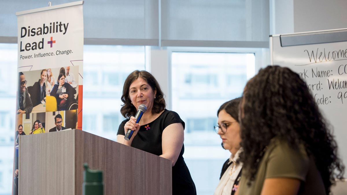 A woman speaking at a podium with a 